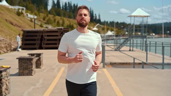 Young man running fast and intense in forest