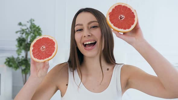 Beautiful Young Woman with Grapefruit on Eyes.