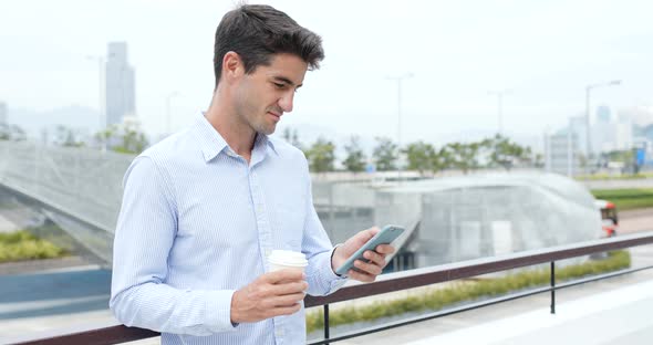 Man hold with mobile phone and drink of coffee