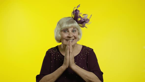 Positive Senior Old Blond Woman Appealing To Camera, Keeping Prayer Gesture and Asking Help