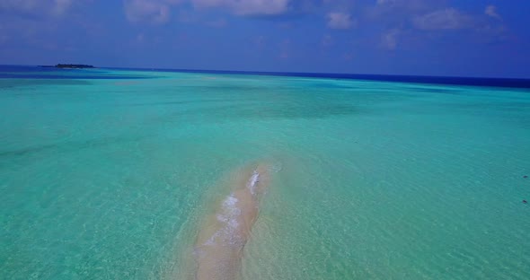 Wide angle overhead tourism shot of a white sandy paradise beach and turquoise sea background in col