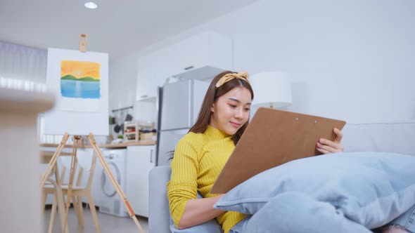 Asian young talented woman artist drawing picture on painting board.