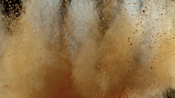 Super Slowmotion Shot of Brown and Silver Powder Explosion Isolated on Black Background