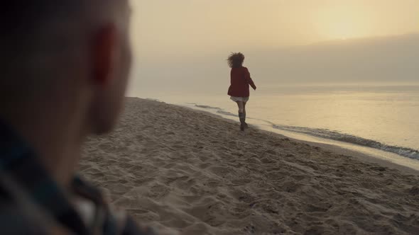 Young Couple Spending Holiday on Beach at Sunrise