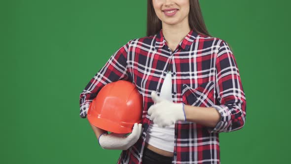 Cropped Shot of a Smiling Female Engineer Showing Thimbs Up Holding Hardhat