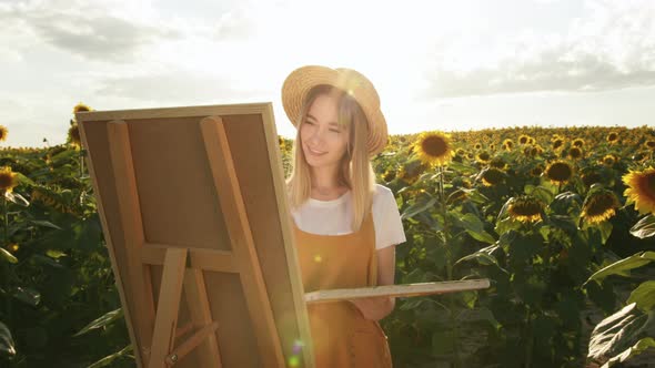 A Woman is Standing in a Field of Sunflowers and Drawing a Picture