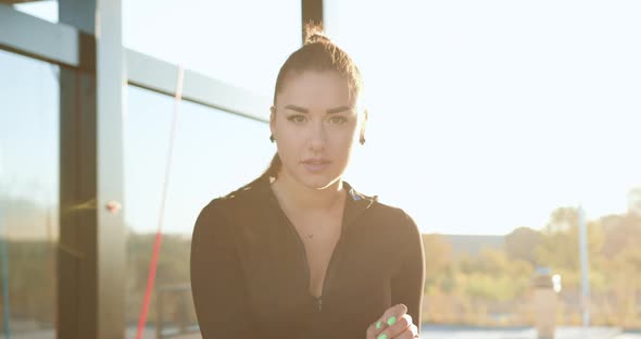 Brunette in Black Clothes with Ponytail which Looking at camera