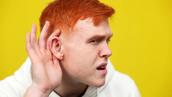 Closeup Side View of Redhead Young Caucasian Man Listening Holding Hand at Ear