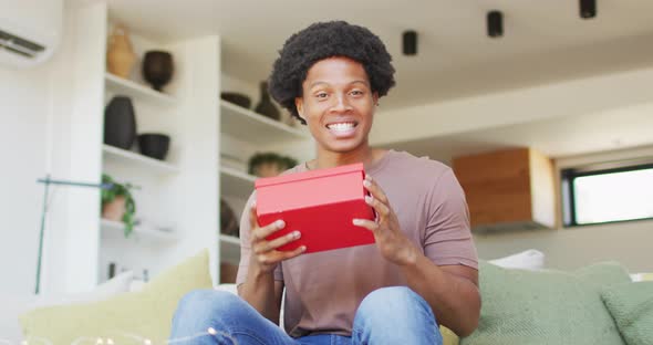 African american man opening gift at home