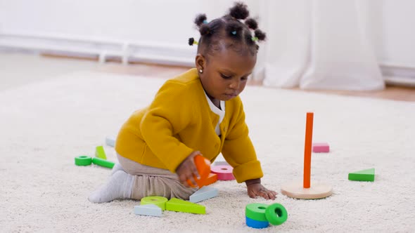 African Baby Girl Playing with Toy Blocks at Home