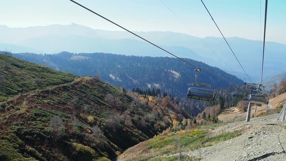 ROSA-KHUTOR, RUSSIA - October 13, 2018. Moving Cabins of the Cable Road. Funicular Moving Over Trees