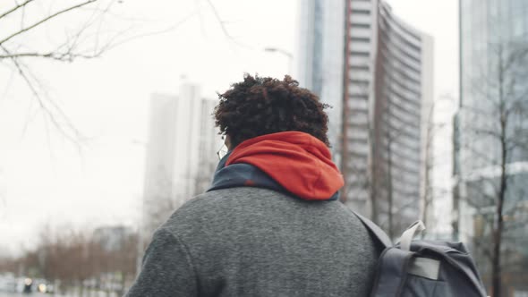 Black Man Drinking Coffee and Walking on Winter Day