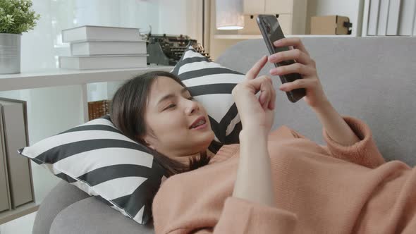 Asian woman holding a smartphone and using online social on lifestyle.