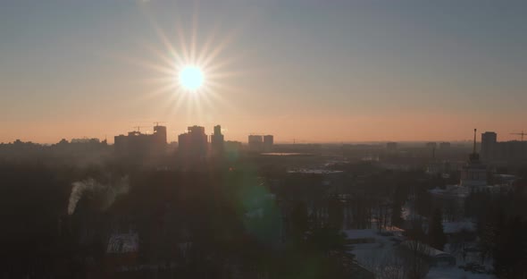 Wonderful Sunset with Sharp Rays on the Background of the City in Winter Aerial Evening View