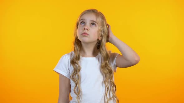 Adorable Girl Scratching Head and Shrugging, Having No Ideas, Feeling Uncertain