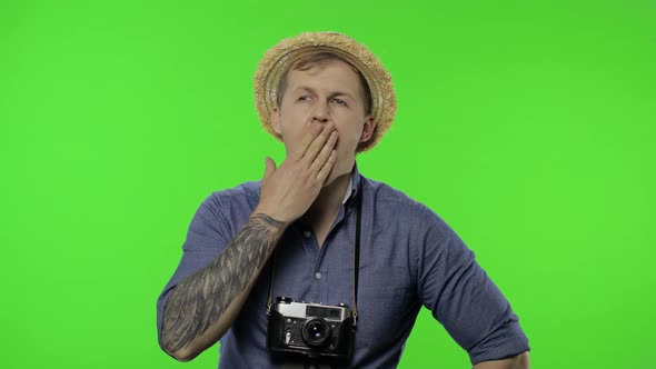 Portrait of Exhausted Man Tourist Photographer Yawns. Chroma Key