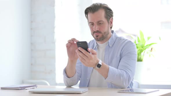 Young Man Using Smartphone in Office
