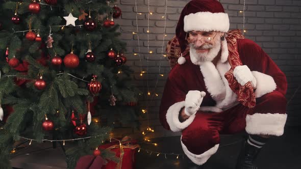 Santa Claus Sitting Quietly Near Xmas Tree and Going To Make Surprise for Kids