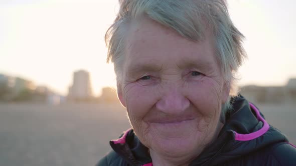 Old Woman Looks Into Camera Walking on Beach in Chioggia