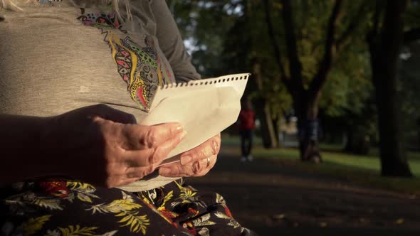 Mature woman reacting to news in a letter in the park medium shot