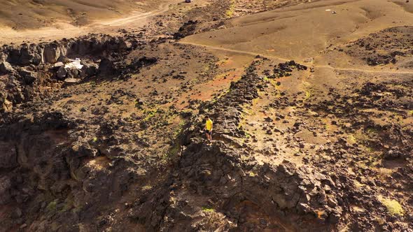 Aerial view of a man walking on rock formation landscape, Lanzarote, Spain.