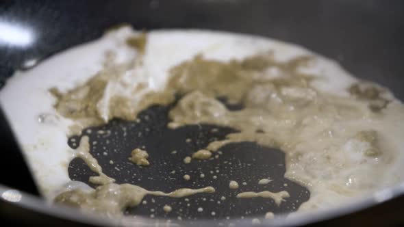 Mixing Green Curry Paste with Hot Sizzling Coconut Milk - Close Up