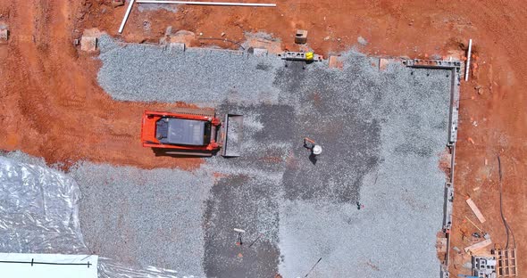 An Excavating Bucket is in the Process of Leveling Gravel for a Building Foundation