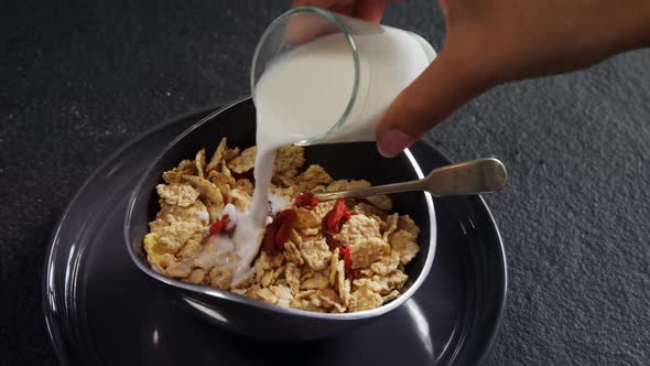 Milk being poured into wheat flakes bowl 4k