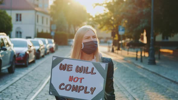 Protest Walk: Woman in a Medical Mask Holding Placard with Words That People Won't Comply