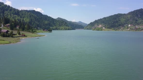 Aerial Slow panning shot of Valley with Lake and trees