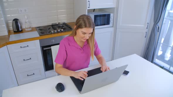 Young adult blond girl working on laptop computer keyboard in 4k stock footage