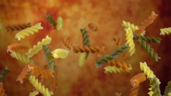 Colored Pasta Fusilli is Bouncing on a Yellow Ochre Background