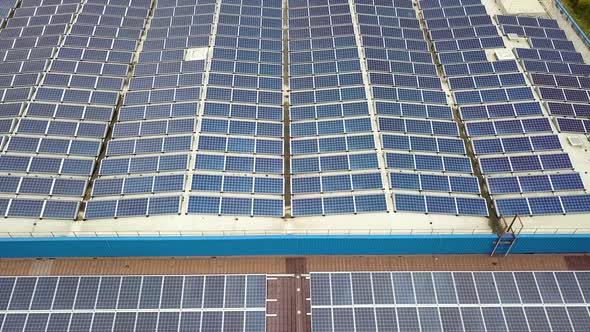 Aerial view of solar power plant with blue photovoltaic panels mounted of industrial building roof