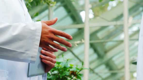 Men shaking hands in greenhouse