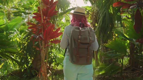 Camera Following Traveler Woman with Vibrant Pink Hair and Backpack Slow Motion
