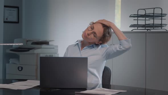 Caucasian Businesswoman Having Neck Pain While Working in Modern Office