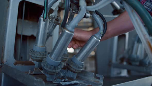 Farmer Checking Milking Equipment on Automated Robotic Dairy Farm Closeup