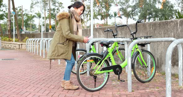 Woman using share bike in city