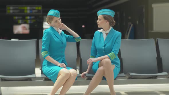 Portrait of Young Stewardess Complaining Neck Pain To Colleague. Slim Gorgeous Caucasian Women in
