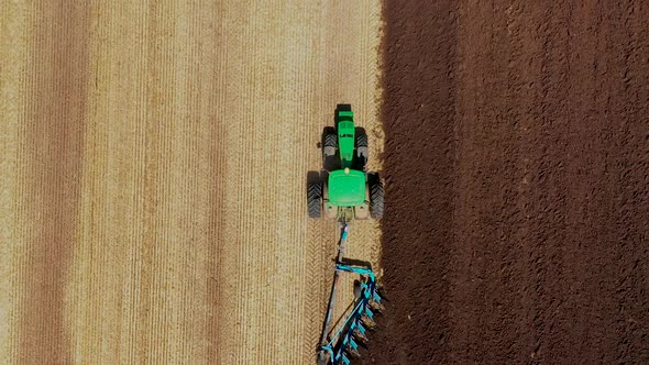 A Tractor Plows a Harvested Corn Field for Future Planting. View From Above