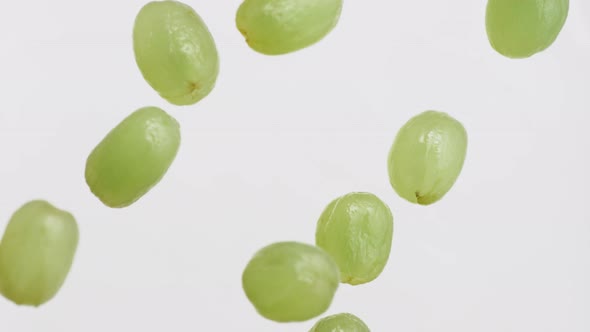 Camera follows tossing grapes in milk. Overhead shot. Slow Motion.