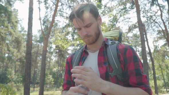 Portrait of Tired Male Hiker Approaching Camera. Drinking Refreshing Water, and Leaving. Close-up of