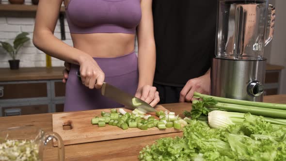 Making Green Juice at Home Female Hands Cut Celery with a Knife on a Board Table in the Kitchen