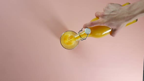 Top view pouring orange juice to a clear glass