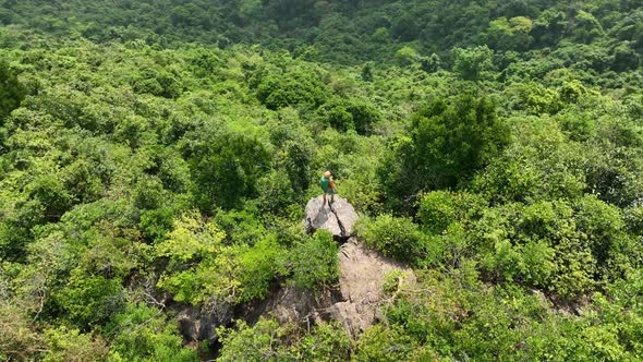 Aerial footage of successful hiker enjoy the view on mountain top cliff edge