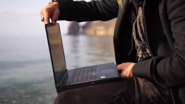 Digital Nomad a Young Tattooed Man Working Remotely Online Typing on a Laptop Keyboard While Sitting