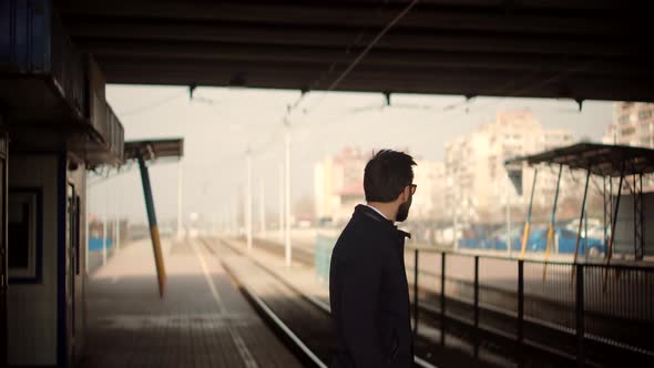 Businessman Hurries To Work And Standing On Railway Train Station Platform. Man Passenger.