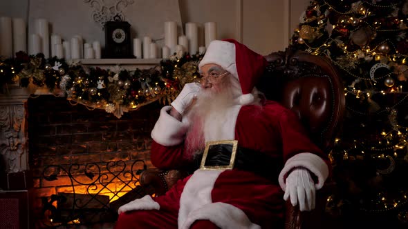 Thoughtful Santa Claus Looking Away Sitting on Chair at Home