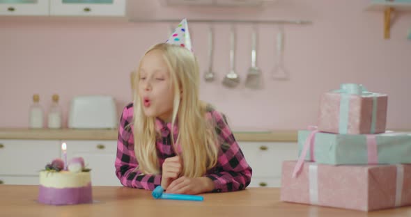 Upset Little Girl Celebrating Birthday Alone at Home. Sad Young Birthday Girl Making a Wish