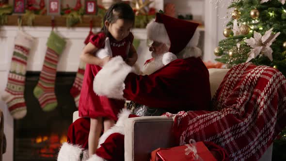 Santa Claus gives present to young girl alt
